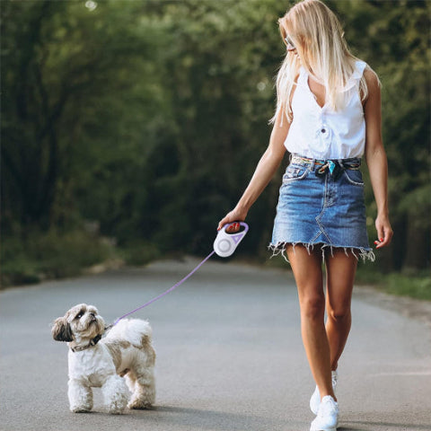 fille qui se promene avec son chien qui porte la laisse rétractable Roulette LED visible