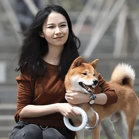 jeune fille qui s'assoit avec son chien qui porte la laisse pour chien led retractable durable