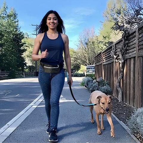une fille qui se promene avec son chien qui porte la laisse pour chien main libre
