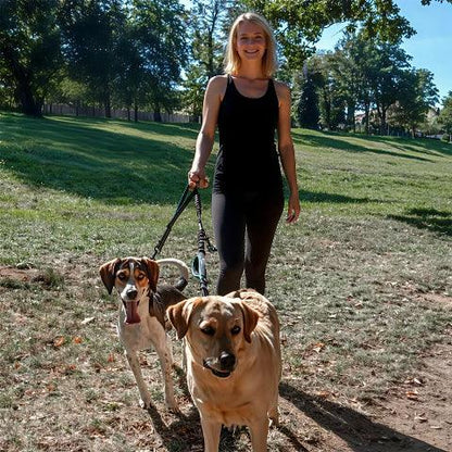 une fille qui se promene avec ses deux chiens avec la laisse double chien double corde bleu ciel